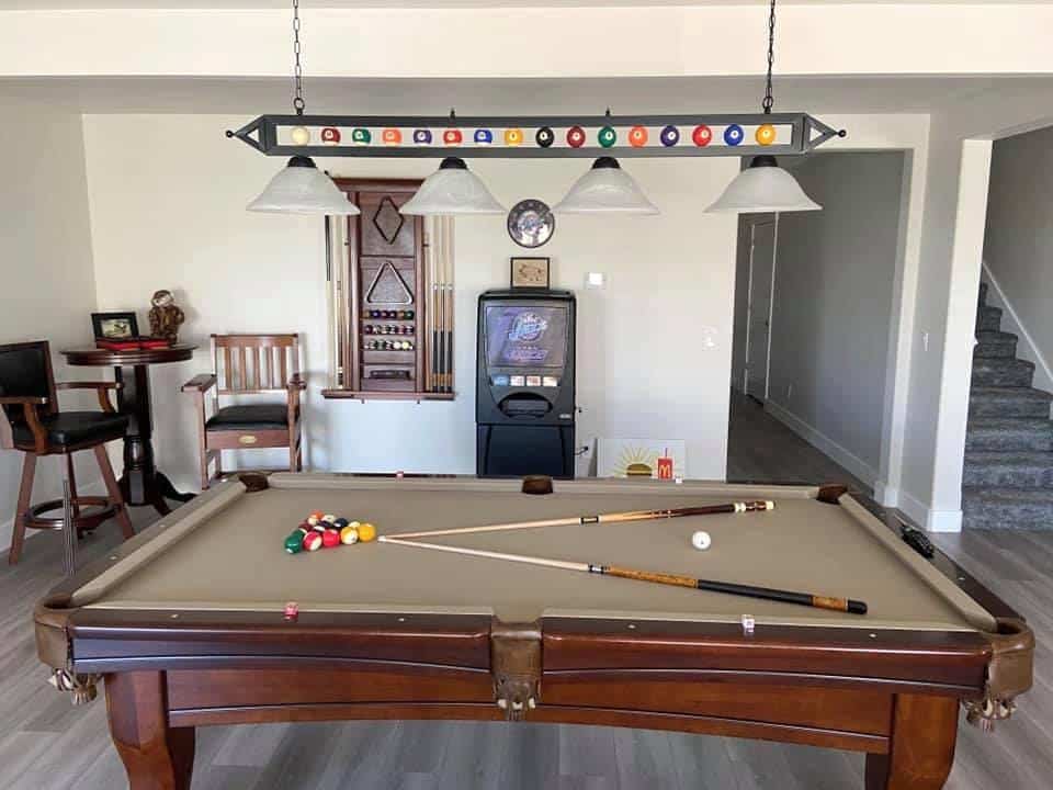 A pool table in a living room with a bar