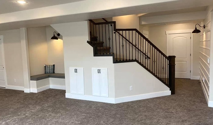 A remodeled basement with stairs leading up to a door.