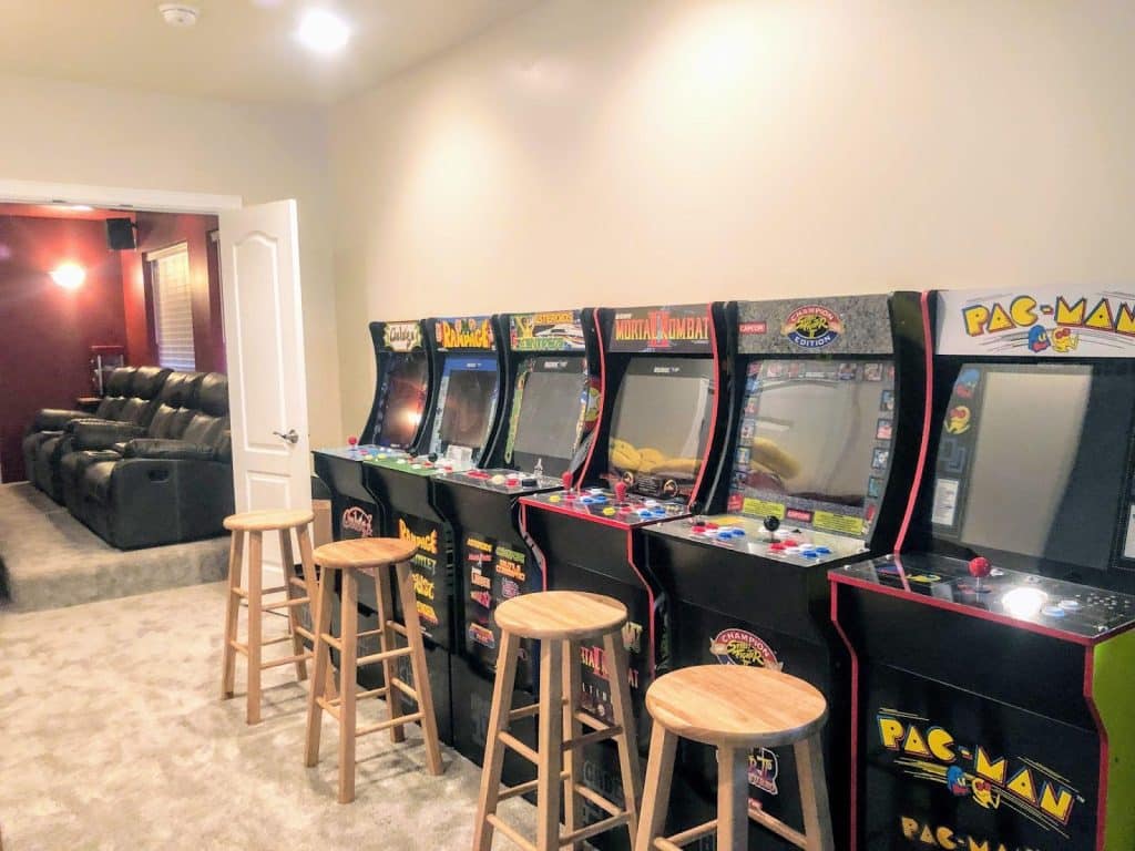 An arcade room with machines and stools for gaming