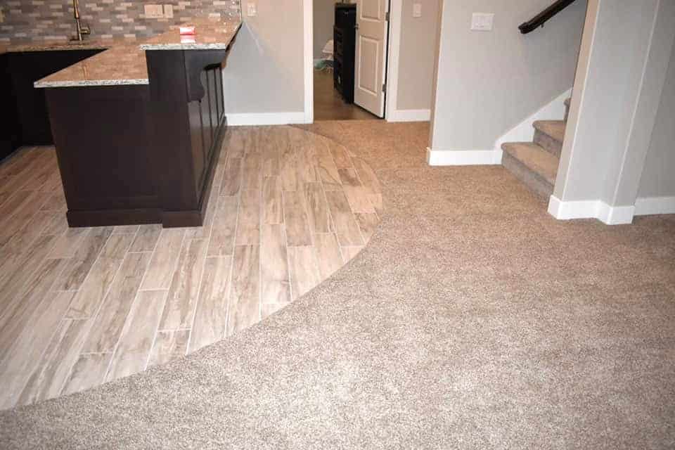 A renovated basement with a curved floor showcasing a kitchen and living room. Perfect for basement renovations and remodels.