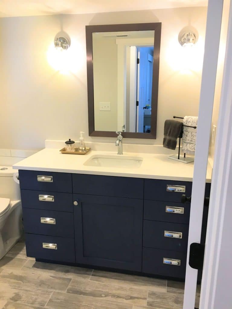 Blue cabinets and white counter tops in basement rental bathroom.