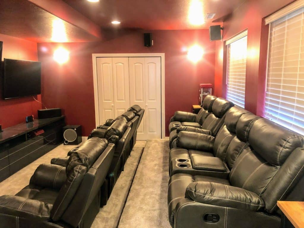 A cozy basement home theater featuring recliners and a large television, perfect for movie lovers to enjoy cinematic experiences.