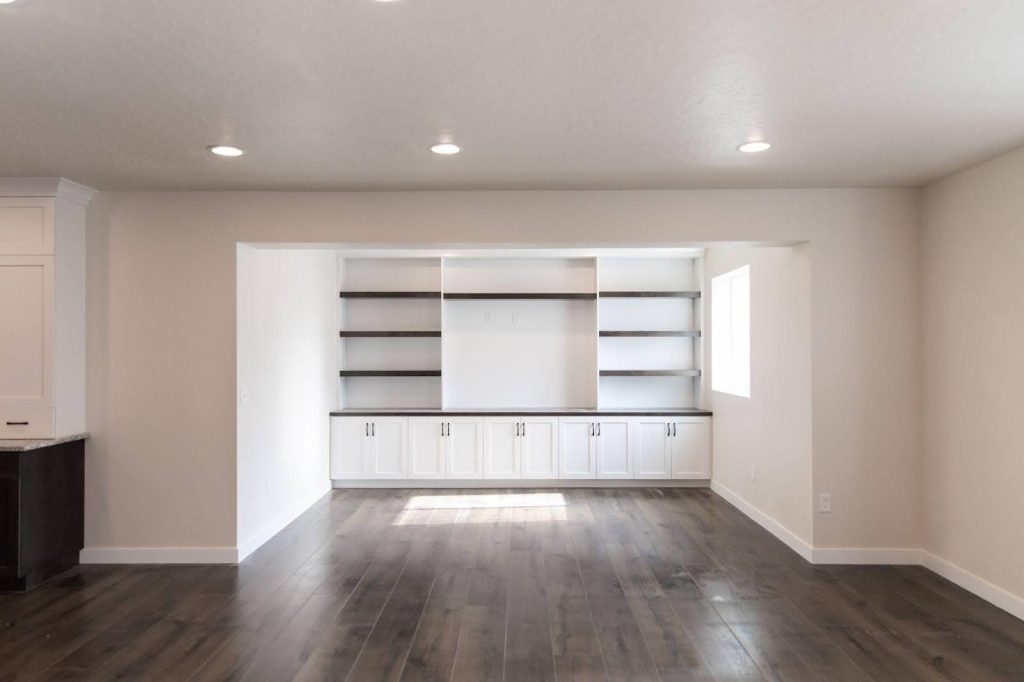 A tidy room with white cabinets and polished hardwood floors, creating a bright atmosphere