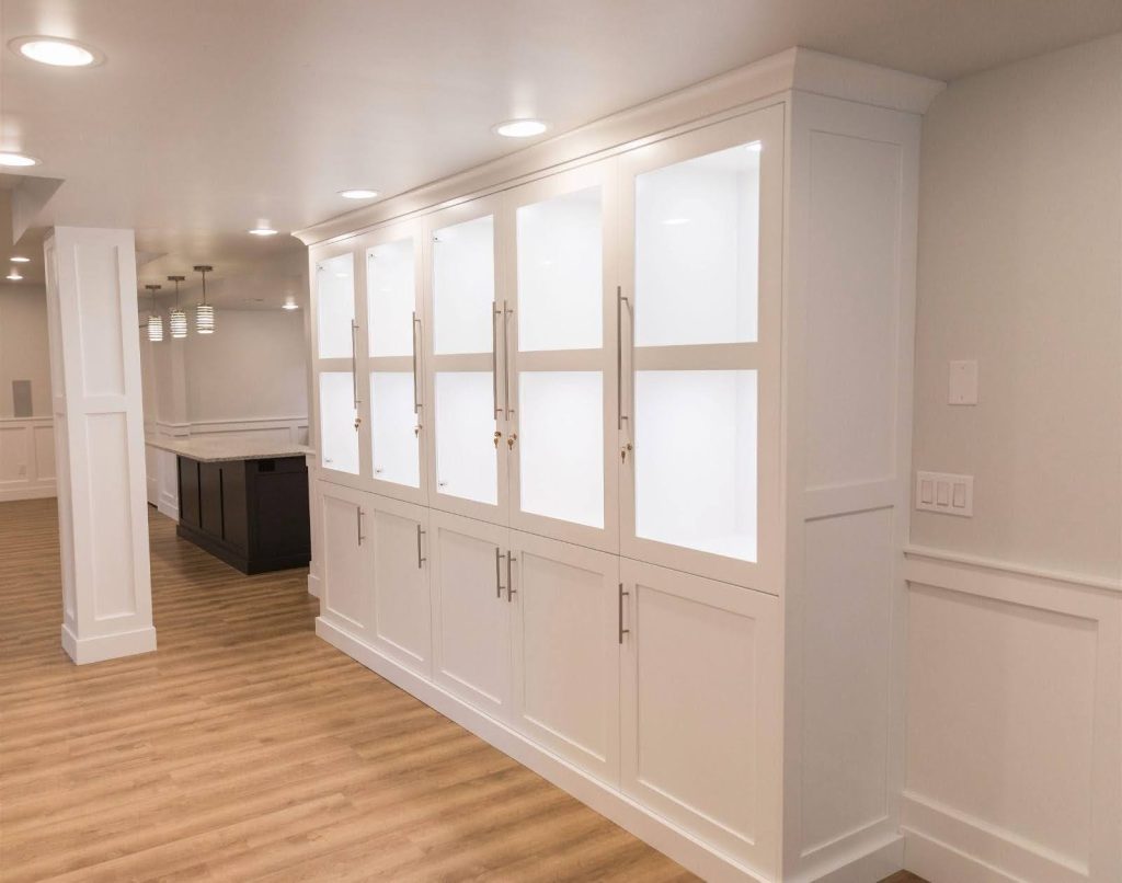 A well-lit hallway featuring white cabinets and modern light fixtures, creating a clean and inviting atmosphere