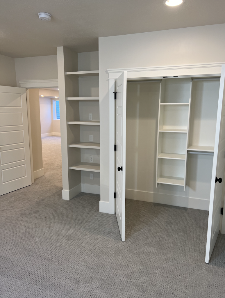 A room with two closets and shelves, showcasing organized storage