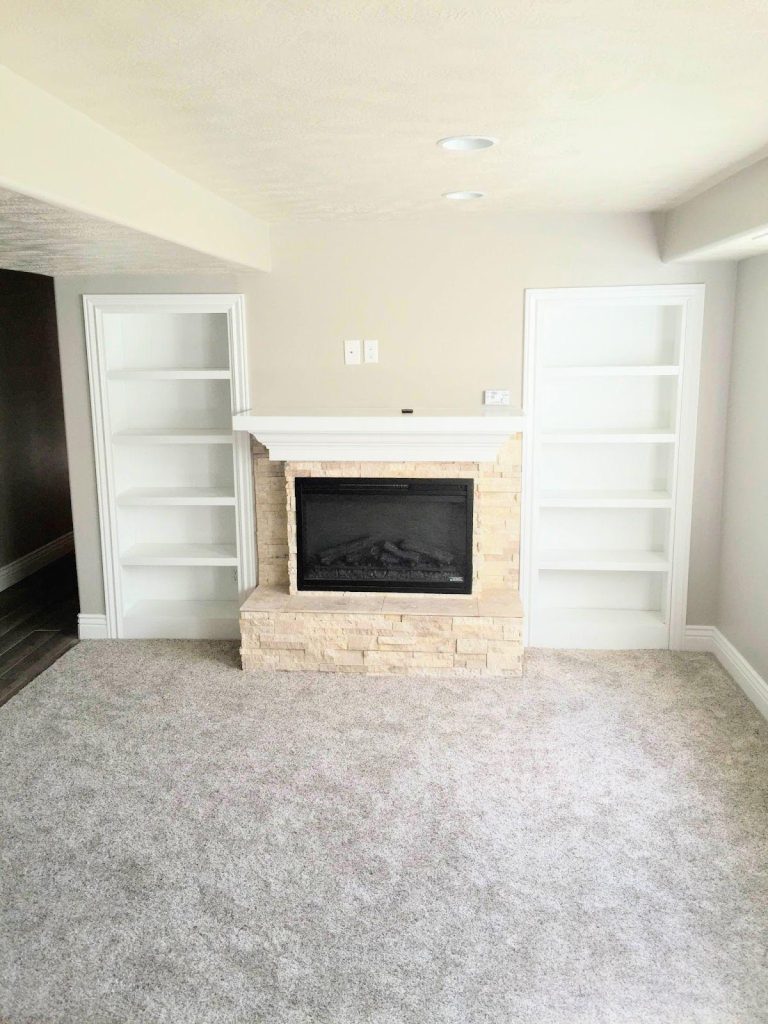 A cozy room with a fireplace and bookshelves, creating a warm atmosphere