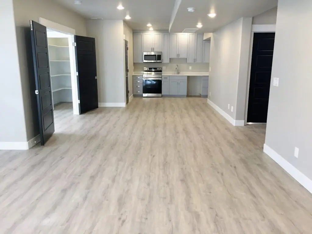 A modern kitchen with gray cabinets, stainless steel appliances, and light wood flooring. - Creative Construction Solutions A modern kitchen with gray cabinets, stainless steel appliances, and light wood flooring.