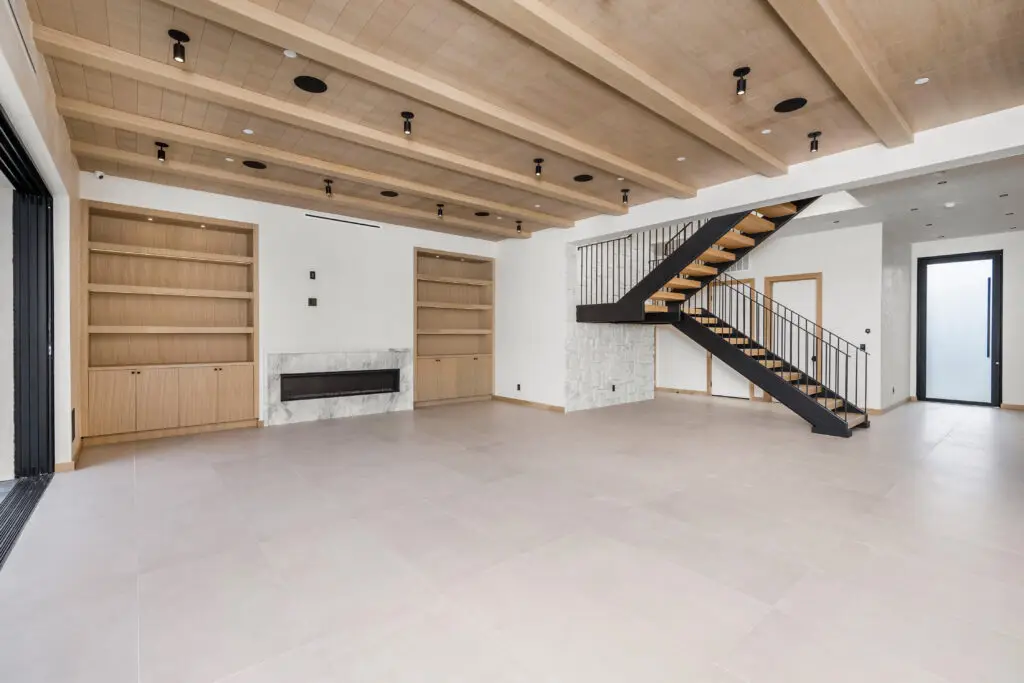 a living room with a wooden staircase and a stair case , Creative Construction Solutions