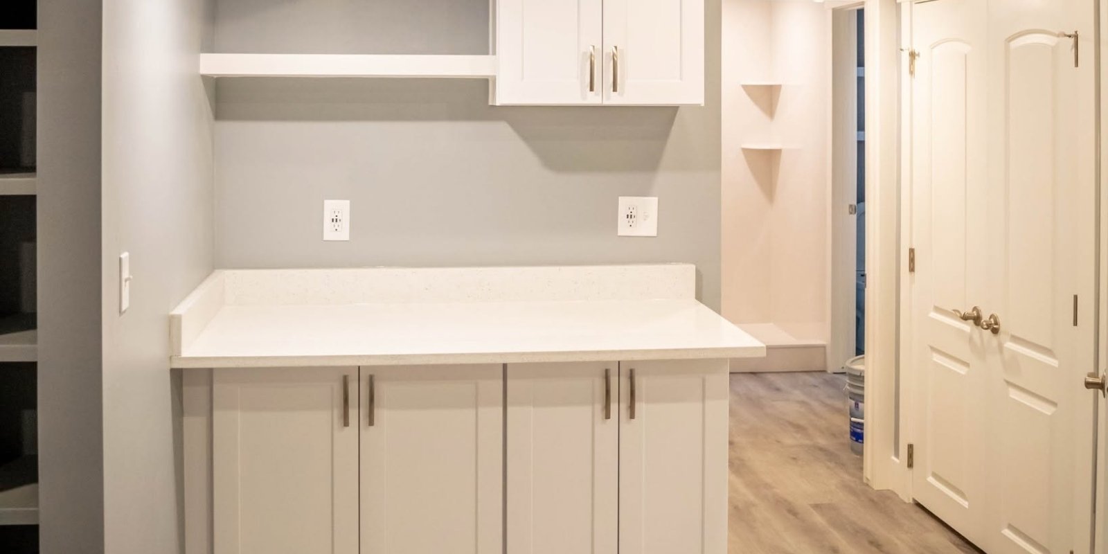 basement remodeling permits bluffdale utah: a simple guide for homeowners 2 A modern light gray finished basement featuring a sleek kitchen counter and cabinetry, representing the high-quality finish expected after completing the Basement remodeling permits Bluffdale Utah inspection process during basement construction.